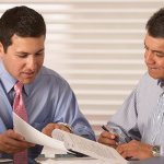 Two men discussing six sigma implementation.