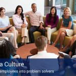 A group of co-workers sitting in a circle talking about the culture of six sigma.