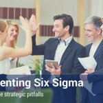 Group of co-workers high-fiving each other after implementing six sigma in the workplace.
