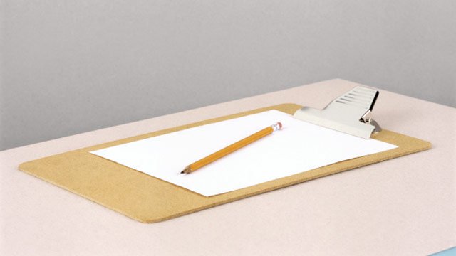 A white table with a wooden clipboard and a blank white sheet of paper and a yellow wooden pencil.