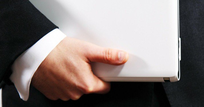 A pair of hands holding a white binder.