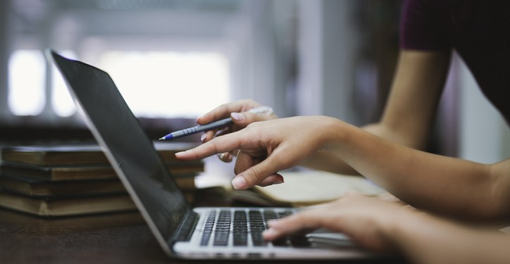 Two professionals pointing to something posted on a computer