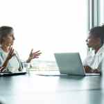 Concept of a Compensation and Benefits Manager sitting with an employee in an office setting